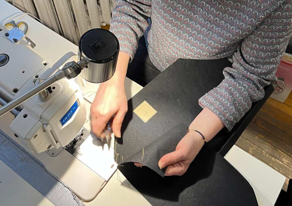 Hands of a craftswoman sewing a vegan bag from plant-based materials – symbol of conscious fashion and the quiet impact of Plant Inside
