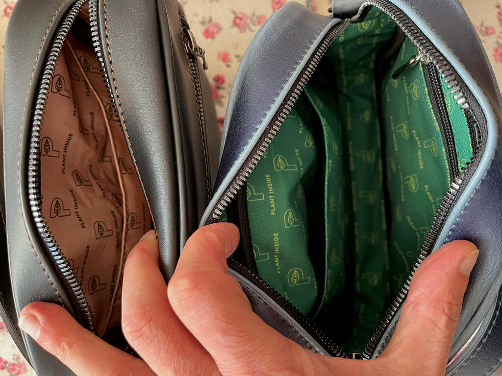 Close-up of the inside of two Plant Inside vegan crossbody bags – one black with beige organic cotton lining, one navy with bold green lining. Stylish, practical and full of character