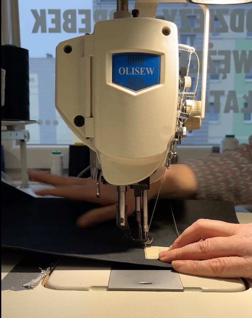 Close-up of artisan Iwona sewing a vegan lunch bag in her workshop in Elbląg, Poland – attaching the Plant Inside logo with precision and care on a sewing machine.