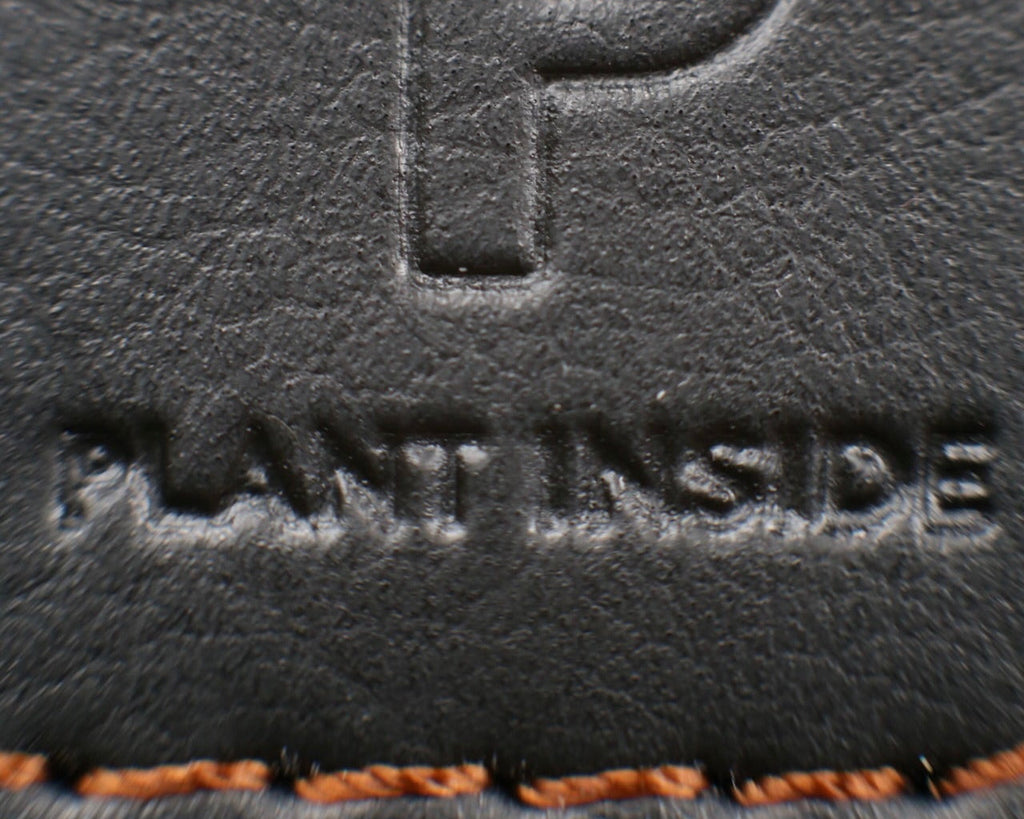 Close-up of Plant Inside logo embossed on Viridis® vegan leather, showing texture and stitching detail – sustainable plant-based material used in handmade bags