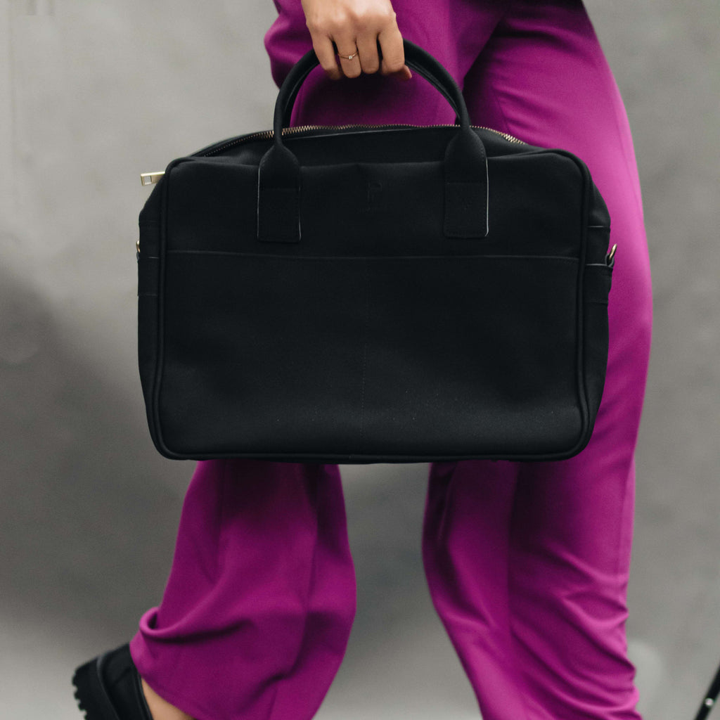 Handcrafted black laptop bag with subtle urban style – symbol of local craftsmanship and global mindset