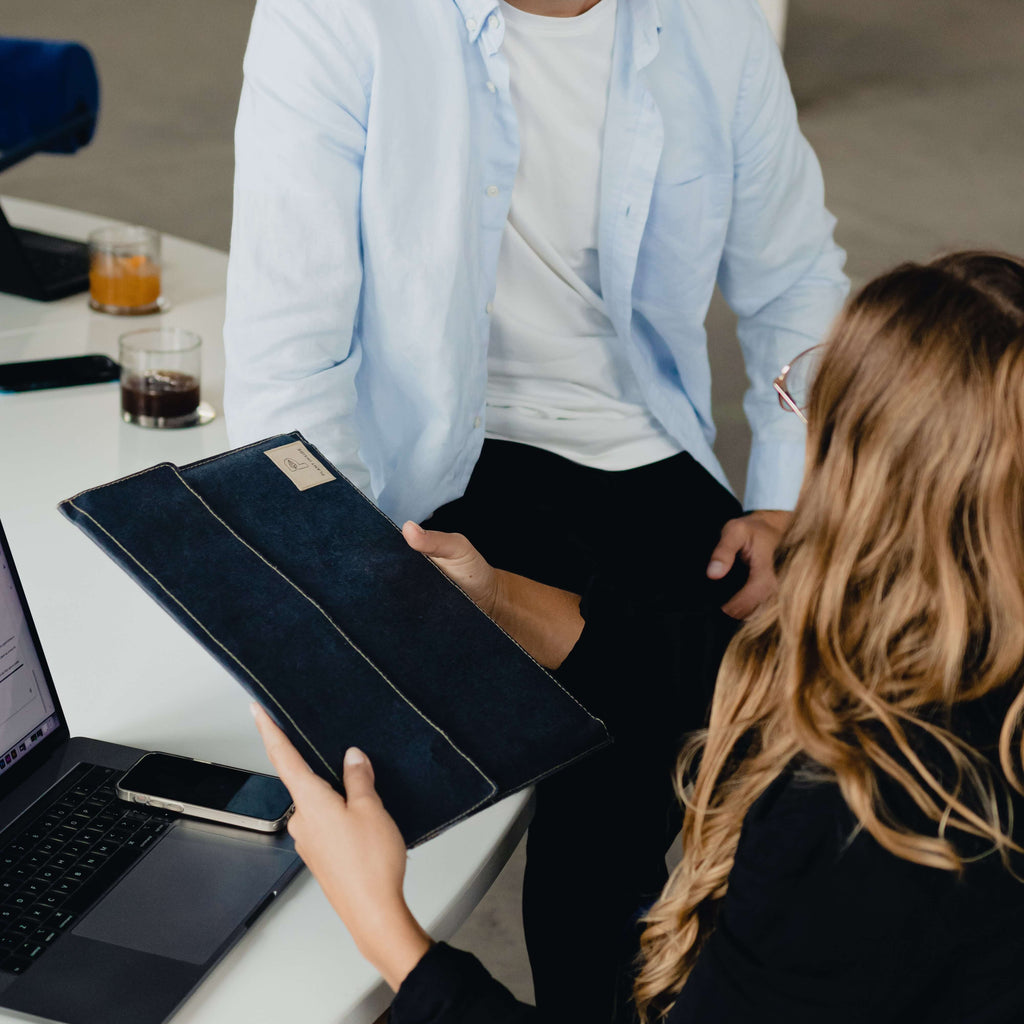 Office moment: sharing a black vegan MacBook sleeve – elegant, practical, and made to last