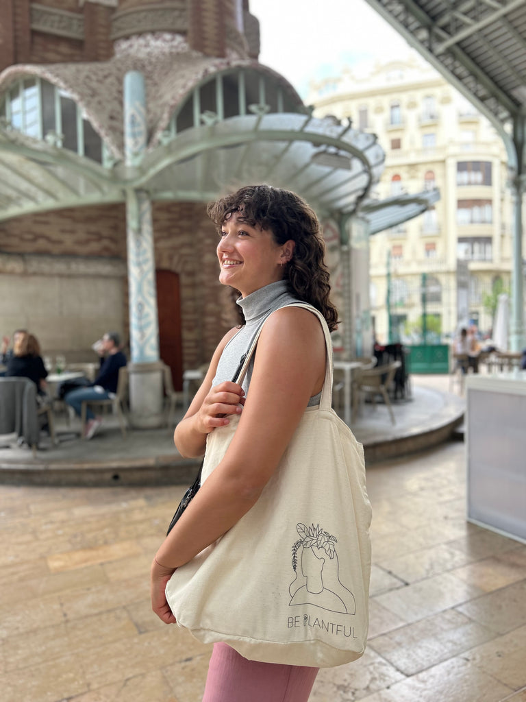 Modern woman with a Plant Inside tote bag in front of a café – everyday moments with purpose